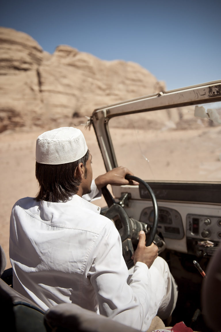 Beduine fährt mit Geländewagen durch Wadi Rum