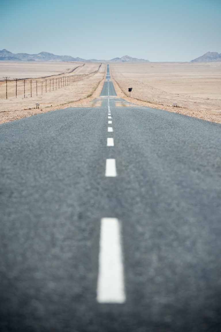 schier endlos gerade Straße führt durch karge Wüste | Fotograf Ulm, Reisereportage Namibia